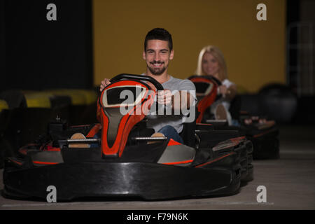 Group Of People Is Driving Go-Kart Car With Speed In A Playground Racing Track - Go Kart Is A Popular Leisure Motor Sports Stock Photo
