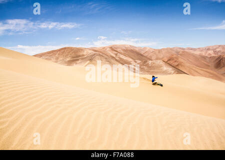 Sandboarding on the dunes of Alto los Verdes, in Atacama Desert. Iquique, Tarapaca Region, Chile. Stock Photo