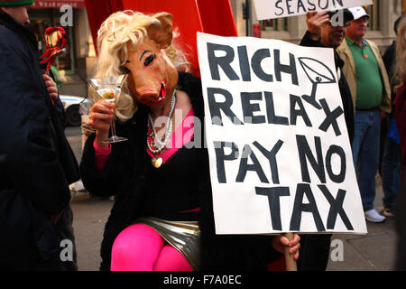 A person in a pig costume holds a sign 'Rich Relax Pay No Tax' at a Occupy Wall Street demonstration in Zuccotti Park. New York, NY. March 17, 2012. Stock Photo