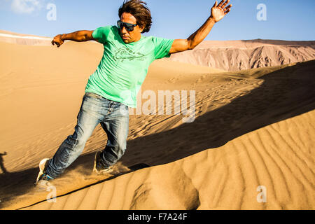 Sandboarding in Cerro Dragon, in Atacama Desert. Iquique, Tarapaca Region, Chile. Stock Photo