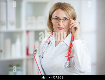 Serious doctor or pharmaceutist woman in glasses looking at camera Stock Photo