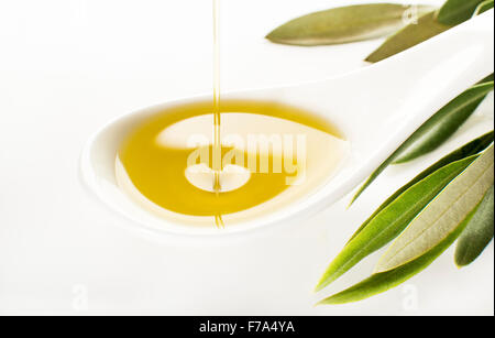 Virgin olive oil pouring on white spoon. Stock Photo