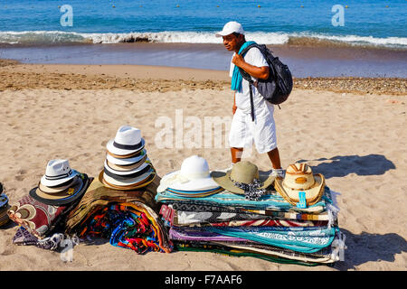 Man selling hats, mats, rugs and clothing on the beach at Puerto Vallarta, Mexico Stock Photo