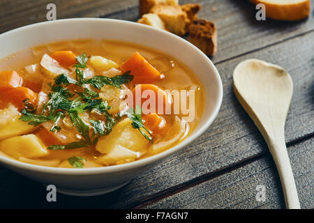 Vegetable soup in white bowl on wooden table Stock Photo