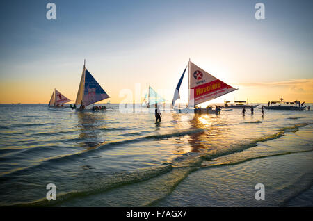 BORACAY, PHILIPPINES - MAY 17, 2015: Traditional philippine sailing boats just before sunset on boracay island, the most tourist Stock Photo