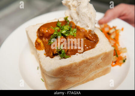 A traditional South African bunny chow, Indian curry served in a hollowed out loaf of bread.  Durban South Africa. Stock Photo