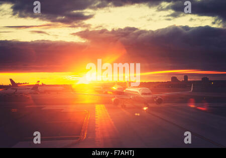 Vintage toned picture of airport at sunset, travel concept, lens flare effect. Stock Photo