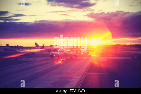 Vintage filtered picture of airport at sunset, travel concept, lens flare effect. Stock Photo
