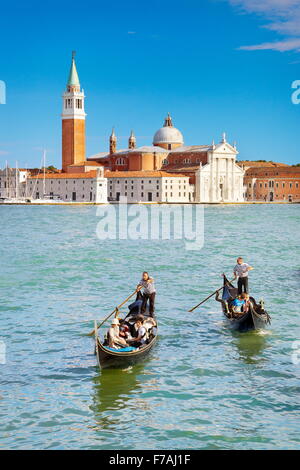 Tourists in venetian gondola on Grand Canal (Canal Grande) and San Giorgio Maggiore church in the background, Venice, Italy Stock Photo