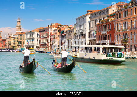 Two venetian gondolas and waterbus on Grand Canal (Canal Grande) - Venice, Italy Stock Photo