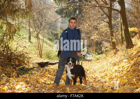 Young man with his dog on autumn walk