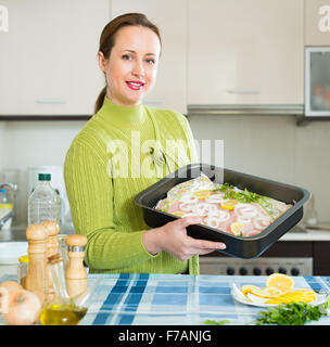 woman preparing slices of white fish for baking Stock Photo