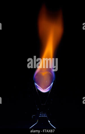 Burning heart shape in the grip on black background