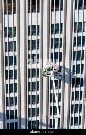 Facade of a building is cleaned, cleaners on a boom lift, Stock Photo