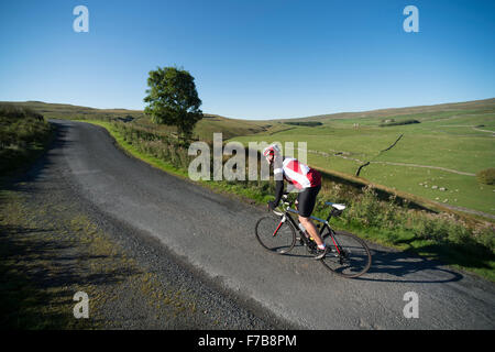 Cycling in the Yorkshire Dales National Park, UK. A lone rider climbing Darnbrook Fell on a beautiful September morning. Stock Photo