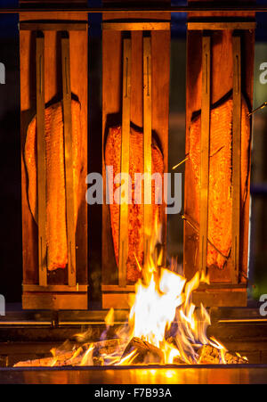 Salmon is smoked and grilled over open fire, specialty on a food market Stock Photo