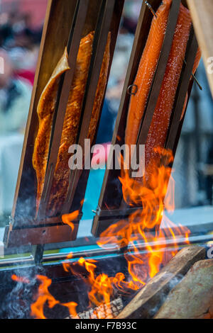 Salmon is smoked and grilled over open fire, specialty on a food market Stock Photo
