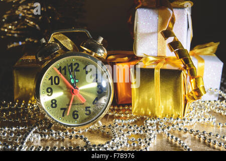 New Year composition with gifts and an alarm clock on a gold background Stock Photo