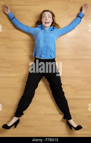 Woman tied up on the floor with black rope, arms and legs out stretched Stock Photo