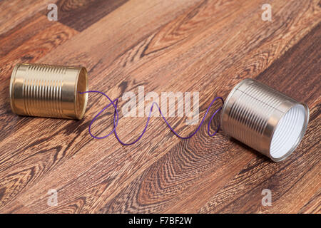 Tin Can Phone on Wooden Background.Communication concept Stock Photo