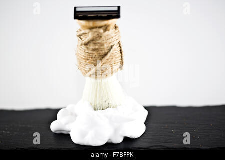 Shaving brush white razor and foam on a blur background Stock Photo