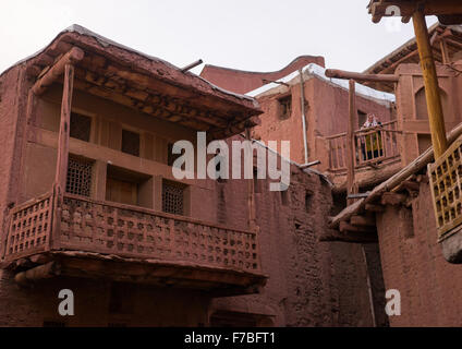 Iranian Woman Standing At The Balcony Of An Ancient Building In Zoroastrian Village, Isfahan Province, Abyaneh, Iran Stock Photo