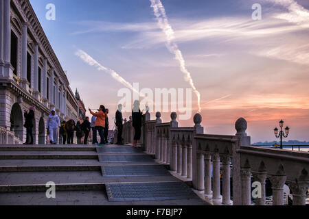 Venice, Italy - Tourists photograph sunrise on the Riva degli Schiavoni next to St Marks basin, Bacino di San Marco, waterfront Stock Photo