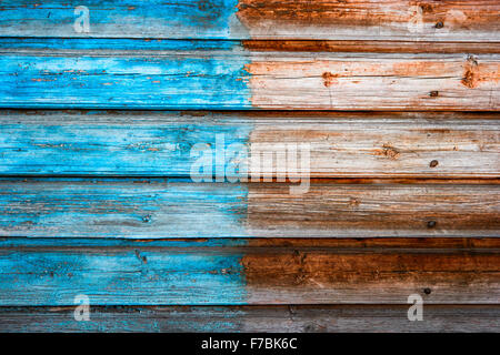 Weathered plank background half painted in blue color Stock Photo