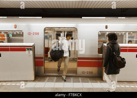 People getting on and off at a Tokyo subway Stock Photo