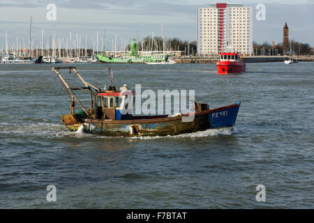 Rusty old fishing boat entering Portsmouth harbour. Entrance to Haslar marina in the background Stock Photo