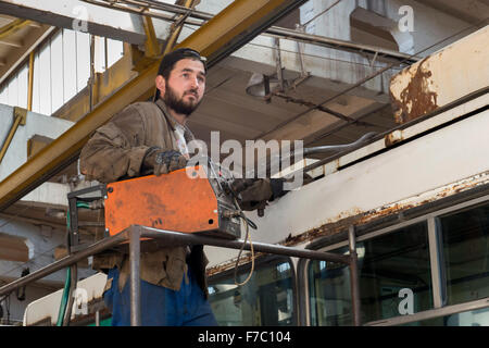 Man Repairing Trolleybus, Repair Shop, Trolleybus Depot, Chisinau Stock Photo