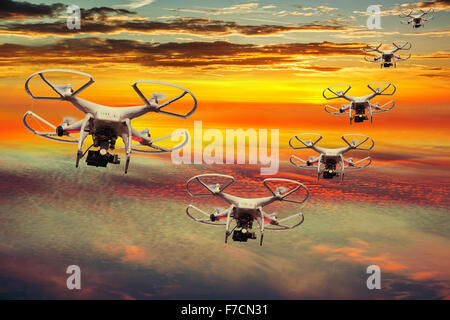The small drones flying in the sunset with dark clouds. Stock Photo