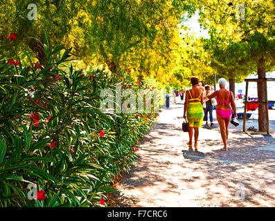 Trieste, Italy, beautiful summer view of Barcola promenade and free strand with women walking in bath suit Stock Photo