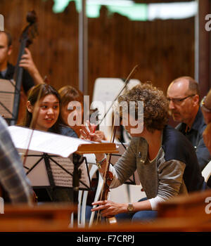 Two young women playing violin in a rehearsal, discussing the music Stock Photo
