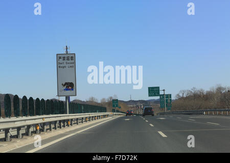 Funny Chinese road sign: Don't Exceed Weight Limit.  Highway G45 Daguang Expressway headed north toward Great Wall. Stock Photo