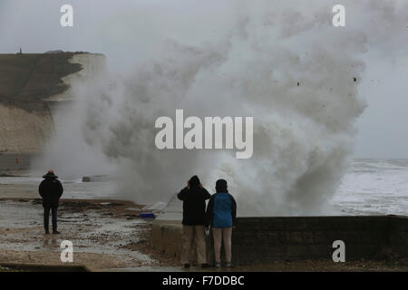 Saltdean, East Sussex, UK. 28th November, 2015. People watch as giant waves crash at the bottom of cliffs near Saltdean as Storm Clodagh batters the East Sussex coast, UK Sunday November 28, 2015.  Regions of Britain were subject to a yellow weather warning for gusting winds upto 60mph.  Photograph : Credit:  Luke MacGregor / Alamy Live News Stock Photo