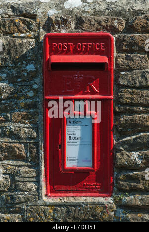 Red post box mounted in stone wall, England. Stock Photo