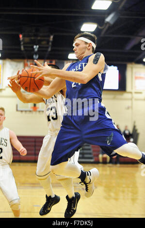 Center seizes a rebound in front of an opposing forward during a high school basketball game. USA. Stock Photo
