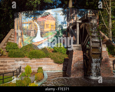 The Waterwheel and the mural, First Chemainus Sawmill 1862 (by Sylvia Verity Dewar) at Waterwheel Park, Chemainus, Canada. Stock Photo