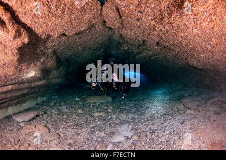 Divers explore natural caves and rocks in the Mediterranean sea off the coast of Larnaca, Cyprus, Stock Photo