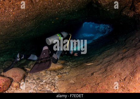 Divers explore natural caves and rocks in the Mediterranean sea off the coast of Larnaca, Cyprus, Stock Photo