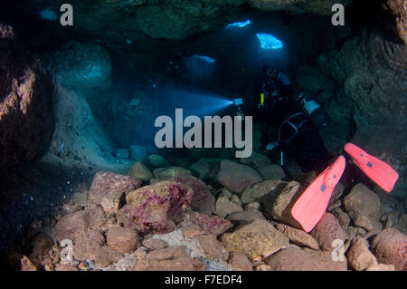 Divers explore natural caves and rocks in the Mediterranean sea off the coast of Larnaca, Cyprus, Stock Photo