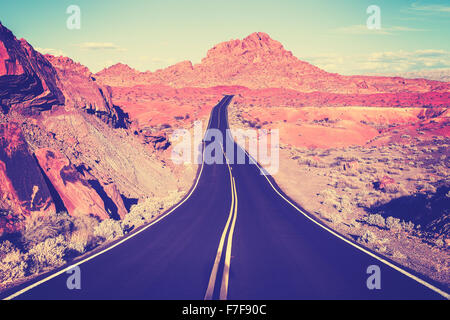 Vintage toned curved desert highway, travel concept, USA. Stock Photo