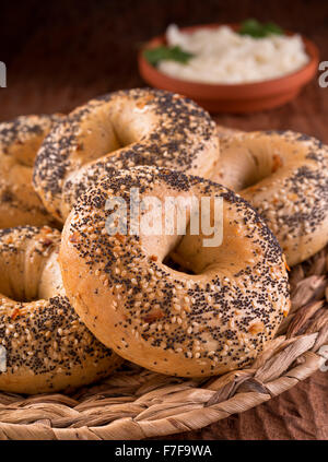 Freshly baked homemade bagels with onion, sesame seed, poppy seed, and cream cheese. Stock Photo