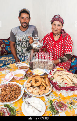 Moroccan man and woman with a spread of snacks and tea. Stock Photo