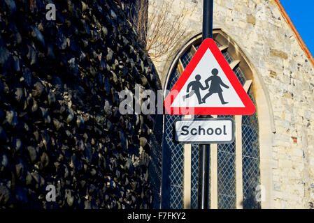School sign, with church window in background, England UK Stock Photo