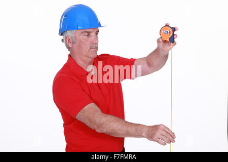 Tradesman using a measuring tape Stock Photo