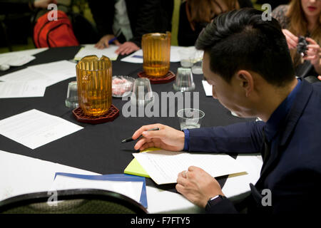 Young Asian man filling out an application at job recruiting fair - Arlington, Virginia USA Stock Photo