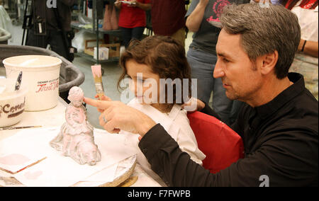 Davenport, Iowa, USA. 30th Nov, 2015. Mike Wolfe encourages his daughter Charlie as she paints a ''Charlie's Smile'' sculpture at the Isabel Bloom Production Facility on Federal Street in Davenport, Iowa Monday, November 30, 2015. © Kevin E. Schmidt/Quad-City Times/Quad-City Times/ZUMA Wire/Alamy Live News Stock Photo