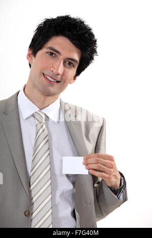 Businessman confidently presenting card Stock Photo